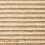 Macro texture of light brown corrugated packaging cardboard with horizontal ridges and visible raw paper fibers.
