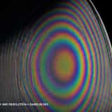 Macro texture of a vintage CRT monitor screen displaying a psychedelic rainbow circular moiré pattern and glowing analog pixels against a black background.