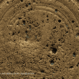 Porous and hammered ancient gold metal texture with circular casting marks and small traces of blue oxidation in the crevices.