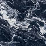 Exotic deep navy blue and black marble texture background with dynamic, flowing white and icy blue swirling veining patterns.