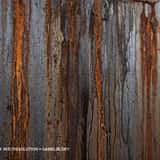 Grunge metal background featuring heavy vertical orange and brown rust streaks dripping down a dark grey steel surface.