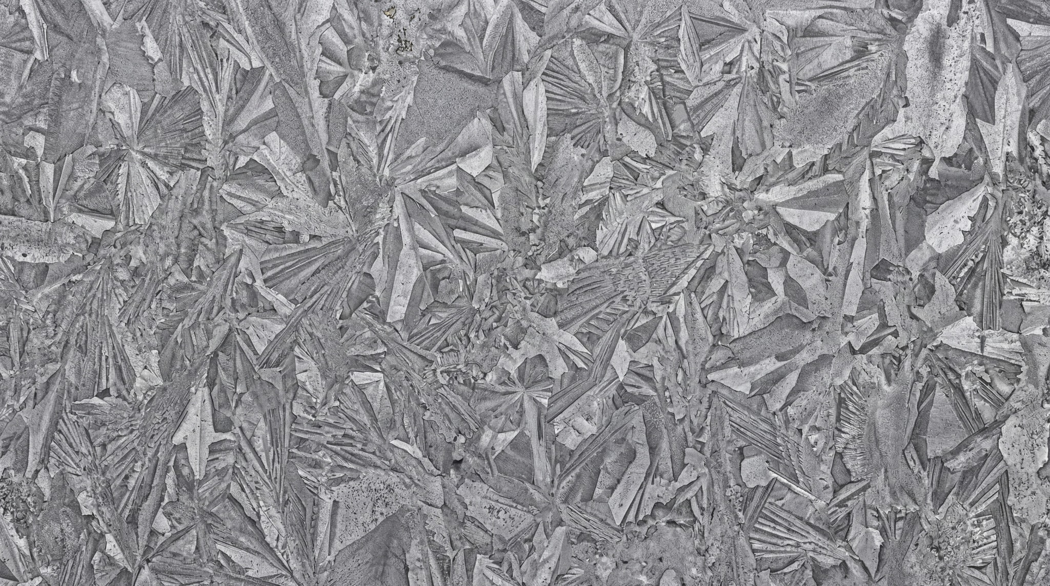 Close-up view of a galvanized steel sheet featuring a distinctive spangle crystal pattern in shades of grey.