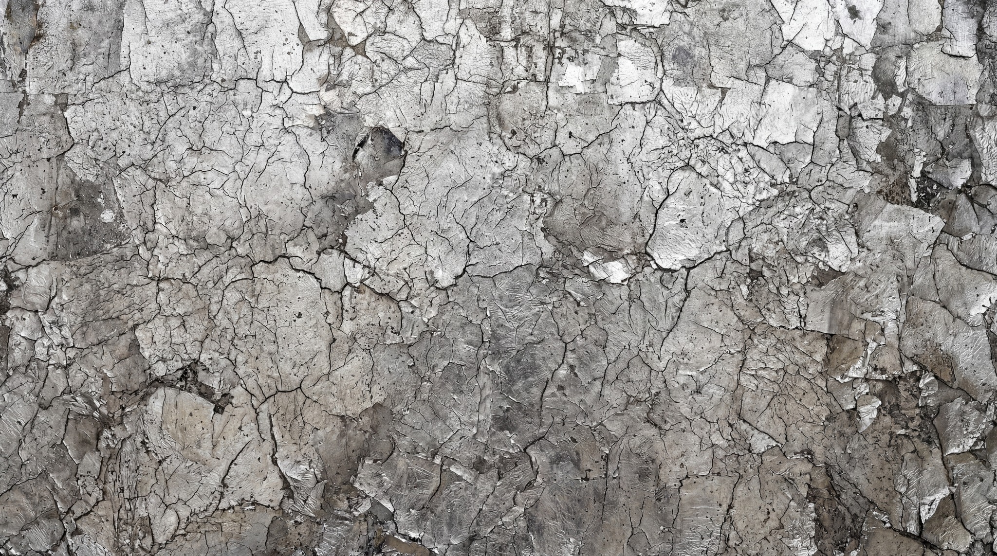 Close-up of a weathered metal surface with heavily cracked and peeling gray paint revealing layers of underlying industrial material.