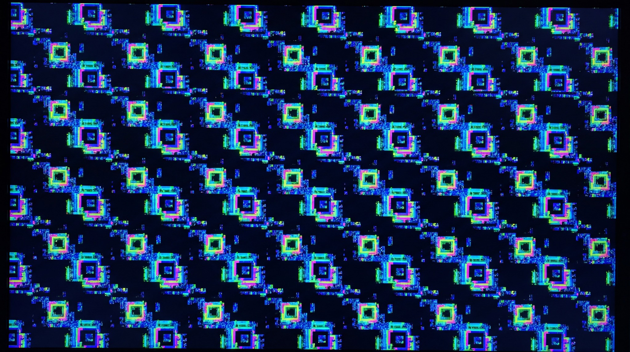 A chaotic overlay of vibrant, pixelated squares in blue, green, and pink, resembling a GPU kernel panic screen.