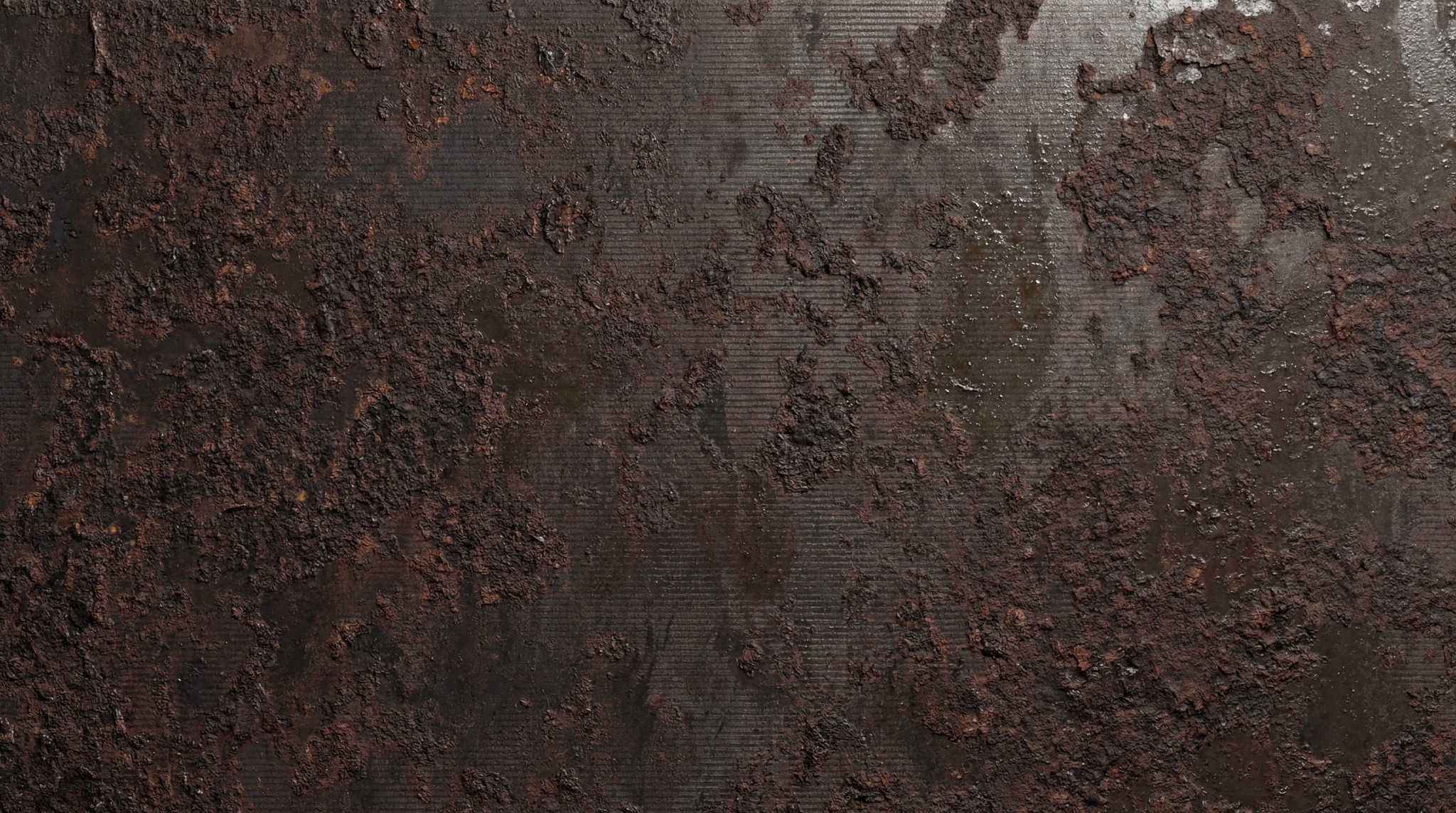 Close-up view of a heavily rusted metal surface with dark brown and reddish-brown textures and fine horizontal lines.