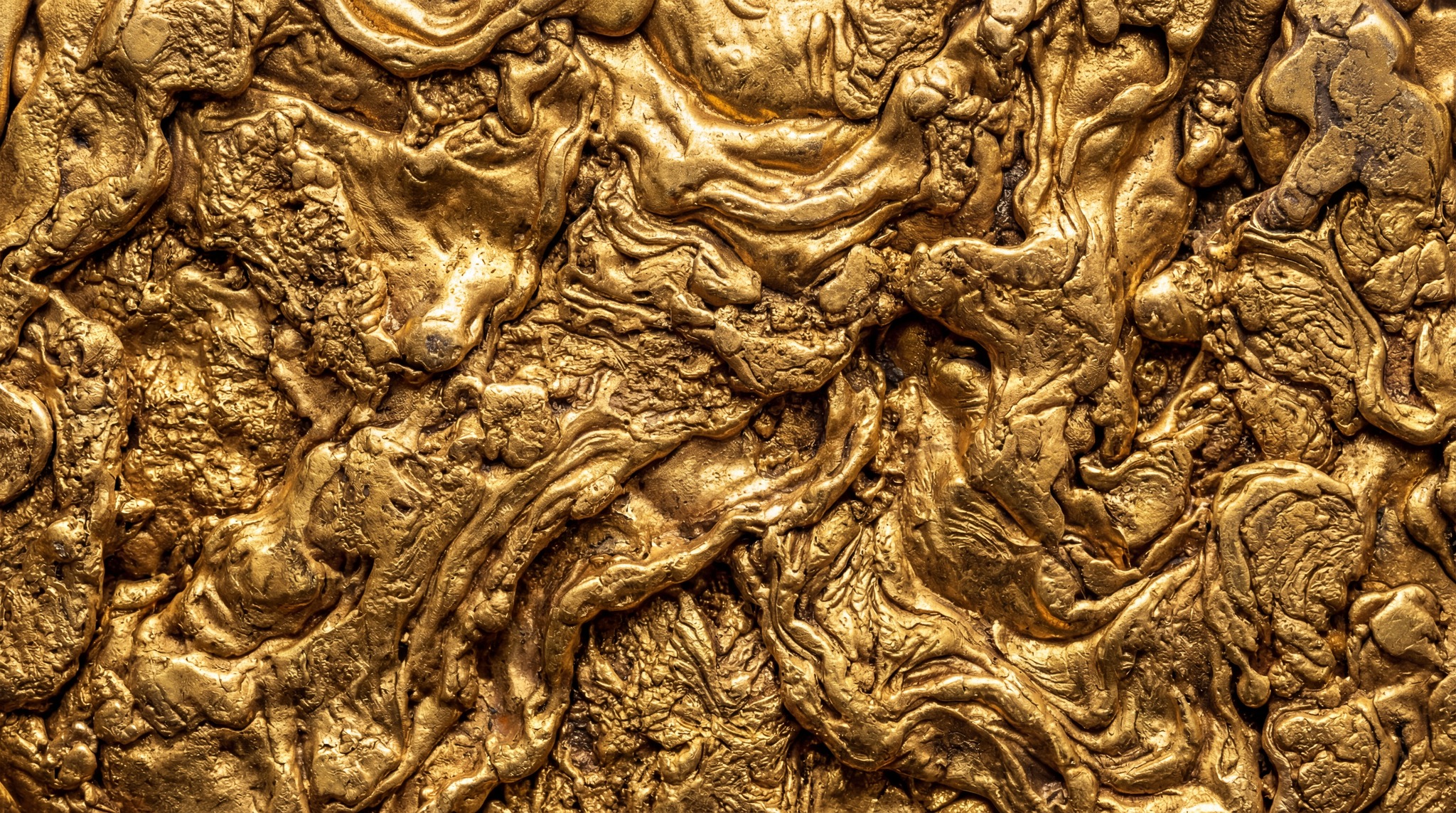 Close-up of a highly textured, molten gold surface with intricate swirling patterns and solidified liquid formations.