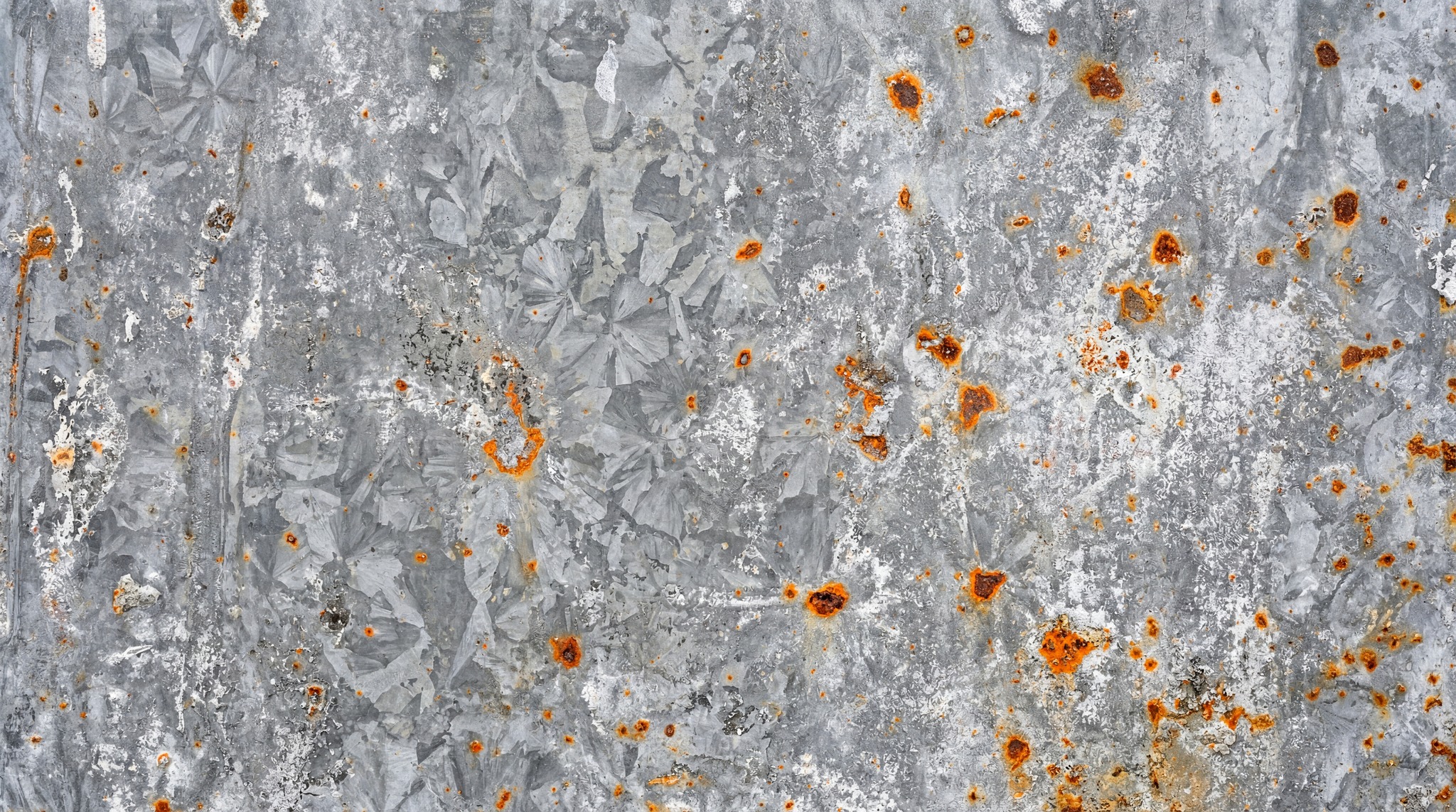 Close-up of galvanized steel with scattered, pitted orange rust.