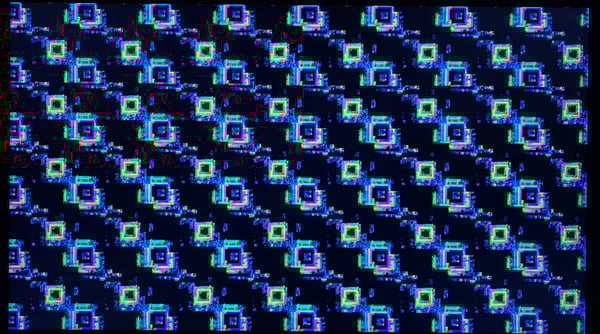 A chaotic overlay of vibrant, pixelated squares in blue, green, and pink, resembling a GPU kernel panic screen.