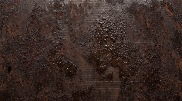 Dark, heavily corroded metal surface with deep pitting and a bubbling, wet appearance.