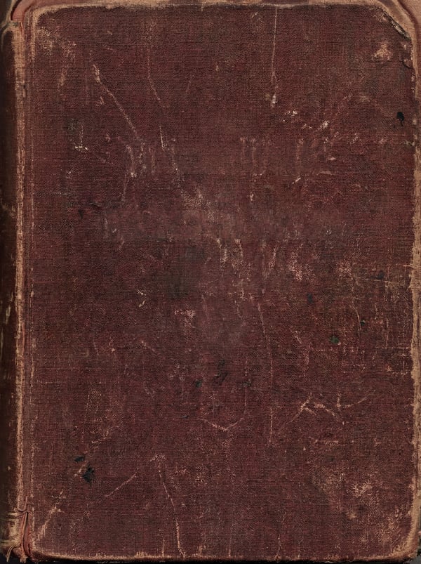 A close-up, top-down view of a worn, dark brown leather book cover with visible scuffs and scratches.