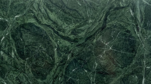 A high-resolution texture of emerald green marble with intricate white swirling veins.