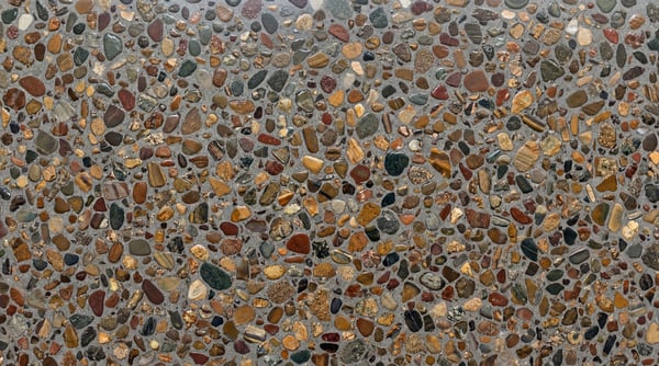 A seamless 4K texture of exposed aggregate concrete with various sized river stones embedded.