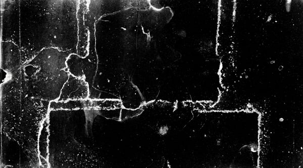 A black background covered in dense white dust particles and jagged scratches, resembling vintage film damage.