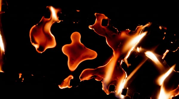 Abstract orange and yellow flames and burnt paper edges on black background, suitable for screen blending.