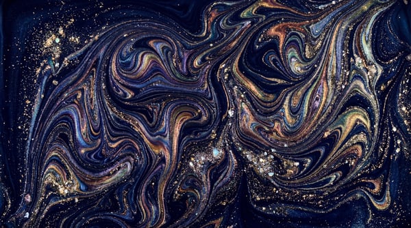 Abstract dark blue marble texture with swirling patterns of iridescent gold, purple, and teal, speckled with glitter.